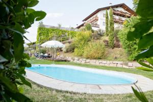 a swimming pool in the yard of a house at Engadiner Apartments & Wines in Montagna