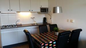 a kitchen with a table and chairs and a sink at DUINZICHT 6 Bed by the Sea in Westkapelle