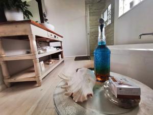 einen Glastisch mit einer Flasche und einem Schädel darauf im Badezimmer in der Unterkunft The Blue Dragonfly in Jeffreys Bay