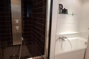 ducha con puerta de cristal junto a la bañera en L'Escapadou - Charme et Tranquillité, en Albi