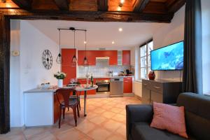 uma cozinha e sala de estar com uma mesa e um sofá em Appartement L'Elégant de la Petite Venise em Colmar