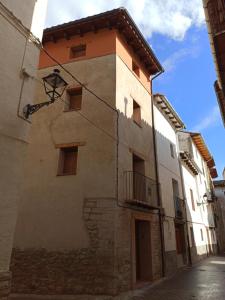 an old building with a balcony on a street at La Caseta in Forcall