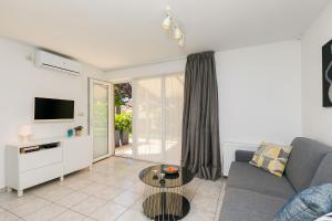 a living room with a couch and a tv at Apartments Dama in Poreč