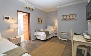 a bedroom with a bed and a desk with a table at Tiende Laan Bed & Breakfast and Self-Catering in Walvis Bay