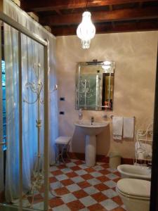 ein Badezimmer mit einem Waschbecken, einem WC und einem Spiegel in der Unterkunft Residenza Torre di San Martino in Gazzola Di Rivalta