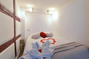 Un dormitorio con una cama con toallas y una flor. en La stub de la Petite Venise, en Colmar