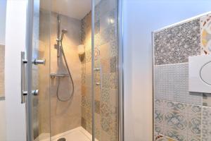 una ducha con puerta de cristal en un baño en La stub de la Petite Venise, en Colmar
