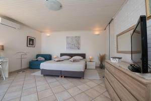 a bedroom with a bed and a flat screen tv at Villa Tomić Apartment Mia near the sea in Opatija