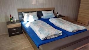 1 dormitorio con 2 camas con sábanas y almohadas azules en Ferienwohnung Schaule en Bolsterlang