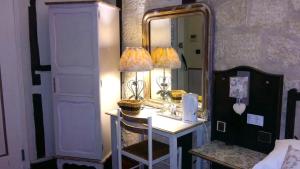 una camera da letto con tavolo da trucco, lampada e specchio di Hotel Mignon ad Avignone