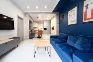 sala de estar con sofá azul y mesa en Дизайнерські апартаменти на вулиці Краківській 17 в центрі Львова, en Leópolis