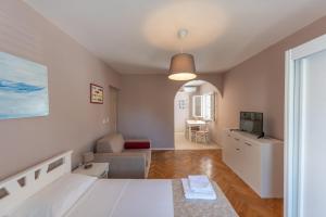 um quarto com uma cama e uma sala de estar em Ioannis Apartments em Tivat
