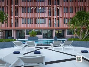 a group of chairs and tables in front of a building at PRIME TOWN - Posh & Port Hotel PHUKET in Phuket