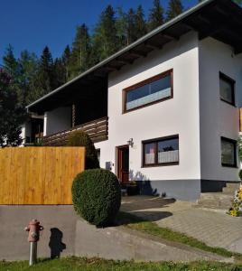 a white house with a wooden fence and a fire hydrant at Ferienwohnung Nagy in Innsbruck