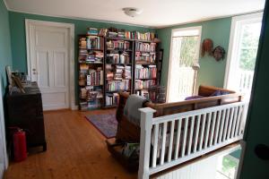 a living room with a book shelf filled with books at Three Pheasants Boutique Bed and Breakfast in Ekeby