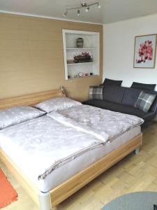 a bedroom with a large bed and a couch at Ferienwohnung Nagy in Innsbruck