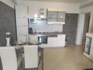 a kitchen with white cabinets and a table in it at Villa Miljana in Kraljevica