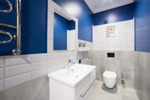 リヴィウにあるApart Hotel on Rynok Squareの青い壁のバスルーム(白い洗面台付)