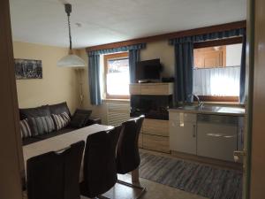 a kitchen and living room with a couch and a table at Ferienwohnung Embacher in Söll