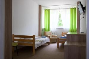a room with a bed and a chair and a window at Prima in Krynica Morska +37 photos