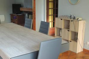 een woonkamer met een grote houten tafel en stoelen bij Maison Andinette in Blis-et-Born
