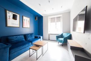リヴィウにあるKraft Boutique Apart-Hotelのリビングルーム(青いソファ、椅子2脚付)