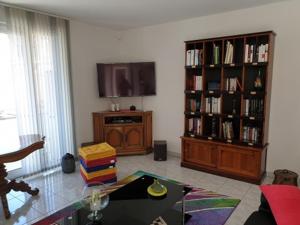 Appartement FOCH à COLMAR في كولمار: غرفة معيشة مع تلفزيون ورف كتاب