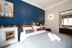 リヴィウにあるKraft Boutique Apart-Hotelのベッドルーム1室(青い壁の大きな白いベッド1台付)