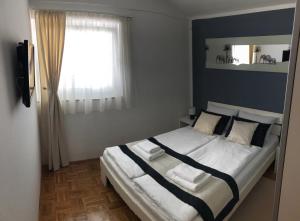 a bedroom with a large bed with a window at Apartments Loncar-near Zrće beach in Novalja