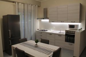 a kitchen with a table and a black refrigerator at Apartments " Le Ginestre" in Acireale