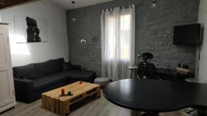 a living room with a black couch and a table at Duplex au Coeur de Lunel in Lunel