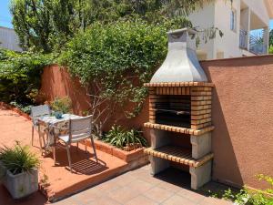 a patio with a brick oven and a table with a chair at Miniestudio en Calafell, cerca Barcelona in Calafell