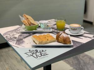 una mesa con dos platos de pan y tazas de café en Affittacamere Il Borgo, en Levanto