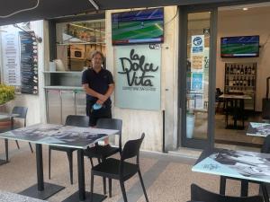 un hombre parado frente a un restaurante con mesas y sillas en Affittacamere Sapore di Mare, en Levanto