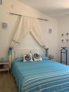 una camera con letto blu a baldacchino di A due passi dal mare e da tutte le attrazioni a Costa Rei