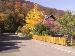 a house with a yellow fence on the side of a road at Haus am Fürstenweg in Neustadt an der Weinstraße