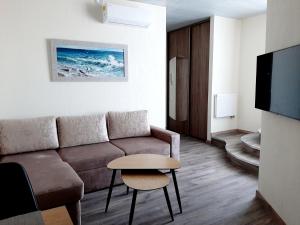 una sala de estar con un sofá y una mesa en Smeltale apartament 3, en Klaipėda