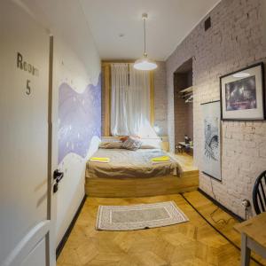 1 dormitorio con 1 cama en una habitación con una pared de ladrillo en GoodMood Hostel, en Moscú