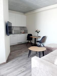 uma sala de estar com uma mesa e uma cozinha em Smeltale apartament 3 em Klaipėda