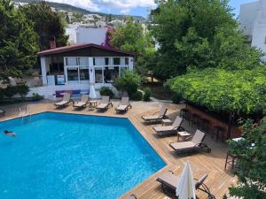 a swimming pool with chaise lounges and chairs on a deck at Costa Bodrum City in Bodrum City