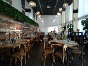 a row of tables and chairs in a room with plants at El Yam in Netanya