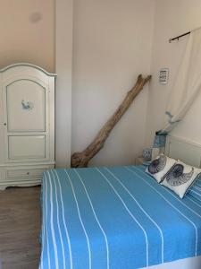 una camera con letto blu e ramo sul muro di A due passi dal mare e da tutte le attrazioni a Costa Rei