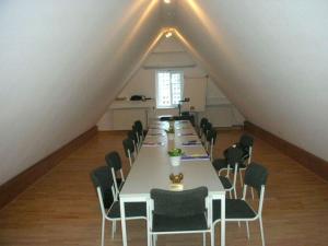 ein langes Esszimmer mit einem langen Tisch und Stühlen in der Unterkunft Krohnprinzenhof Hotel Garni und Ferienwohnungen in Fargau-Pratjau
