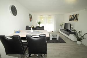 un soggiorno con tavolo, sedie e TV di Ferienwohnung Haus Felix a Bad Elster