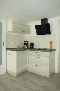 a kitchen with white cabinets and a black counter top at Ferienwohnung Haus Felix in Bad Elster