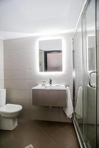 łazienka z umywalką, toaletą i lustrem w obiekcie B12 new & modern seafront apartment w Aleksandropolis +28 zdjęć