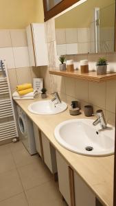 een badkamer met 2 wastafels en een wasmachine bij Apartment 202 in Tatranská Lomnica