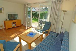 a living room with a blue couch and a table at Ferienhaus das Blaue Haus WS-9a in Born