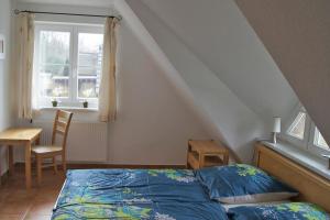 a bedroom with a bed and a table and a window at Ferienhaus das Blaue Haus WS-9a in Born