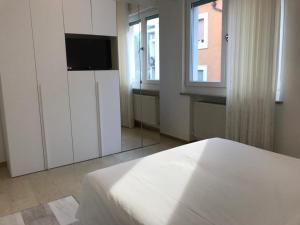 a bedroom with a bed and a tv and a window at Eagle Rooms in Riva del Garda